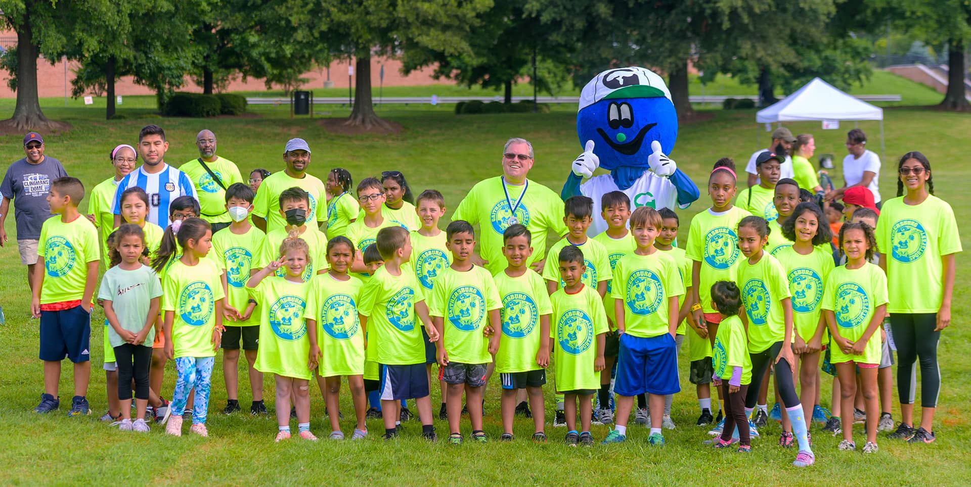 Mayor Jud Ashman with kids at Sportsfest banner